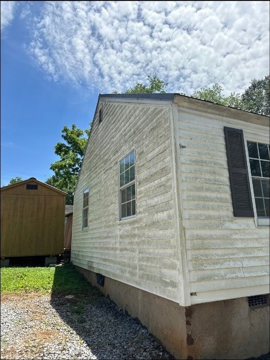Before — Soft washing a home's siding — green algae lifted to clean